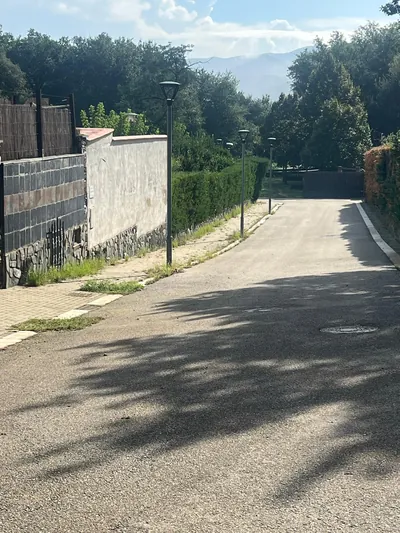 Calle en pendiente con vegetación junto a la acera de Can Sans en Sant Celoni