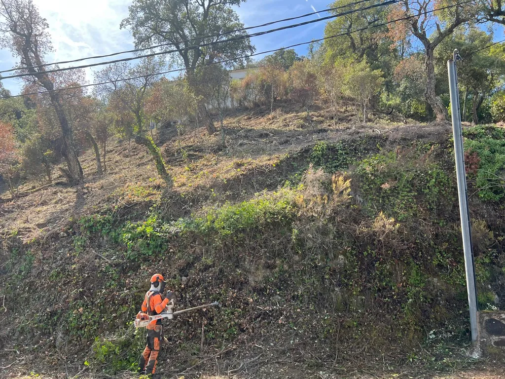 Operario con desbrozadora profesional trabajando en la pendiente de Vall Repòs, Santa Cristina d’Aro.